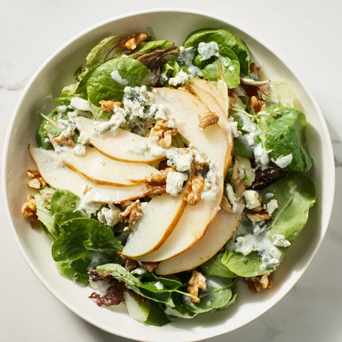 Fresh Frosted Pear Greens salad with creamy dressing, perfect for a light, delicious meal.