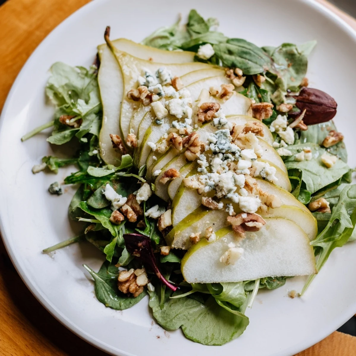 Perfectly composed Winter Pear Greens salad with vibrant greens and juicy pear slices.
