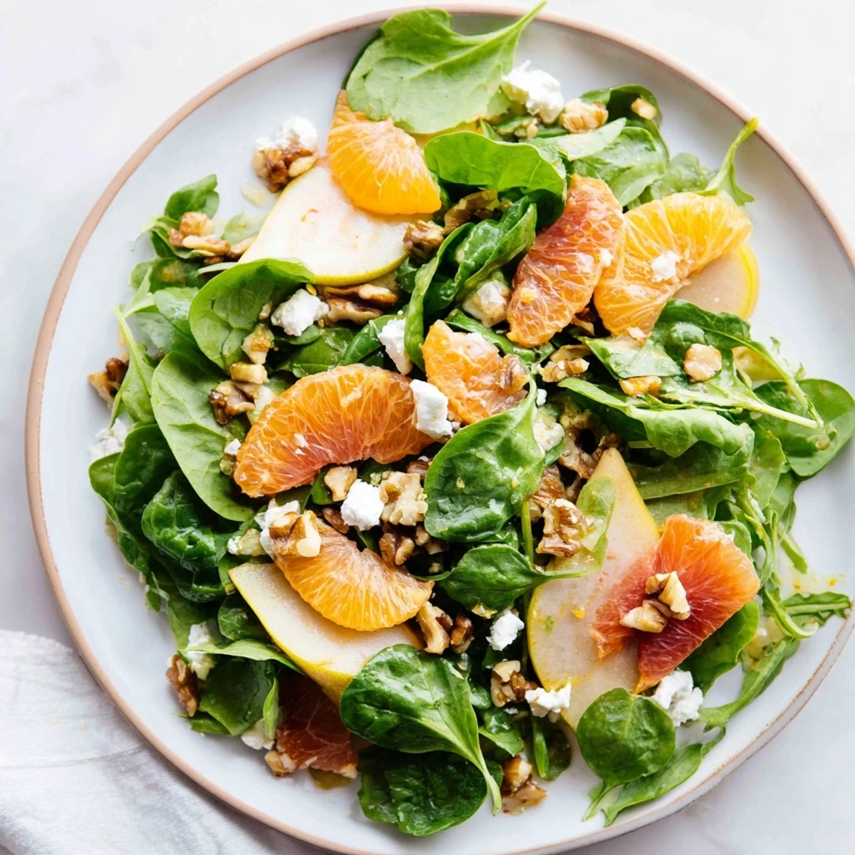 Citrus Pear Greens salad with vibrant orange segments and creamy goat cheese crumbles.