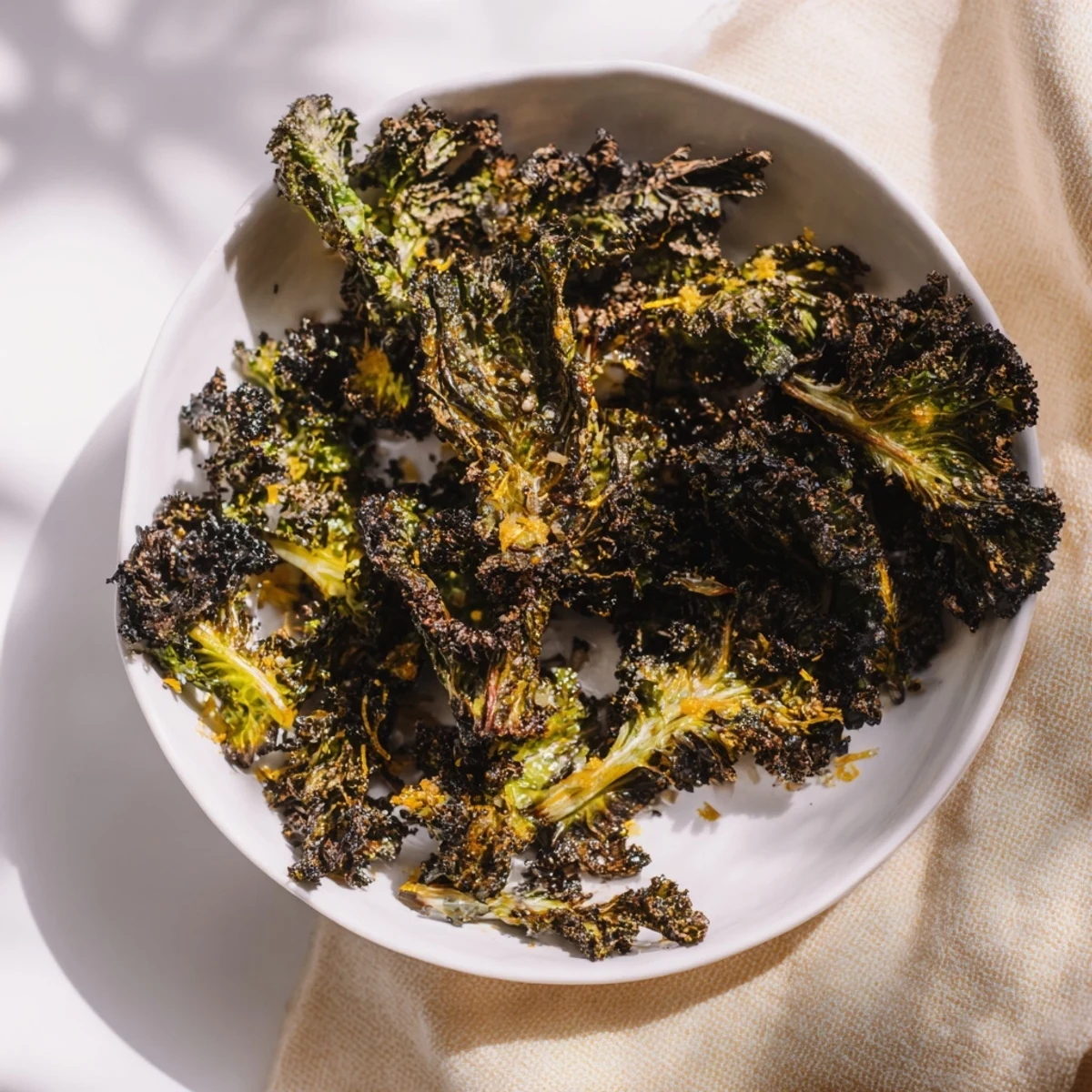 Crispy, roasted Hearth Kale leaves ready to eat, garnished with nuts and lemon zest.
