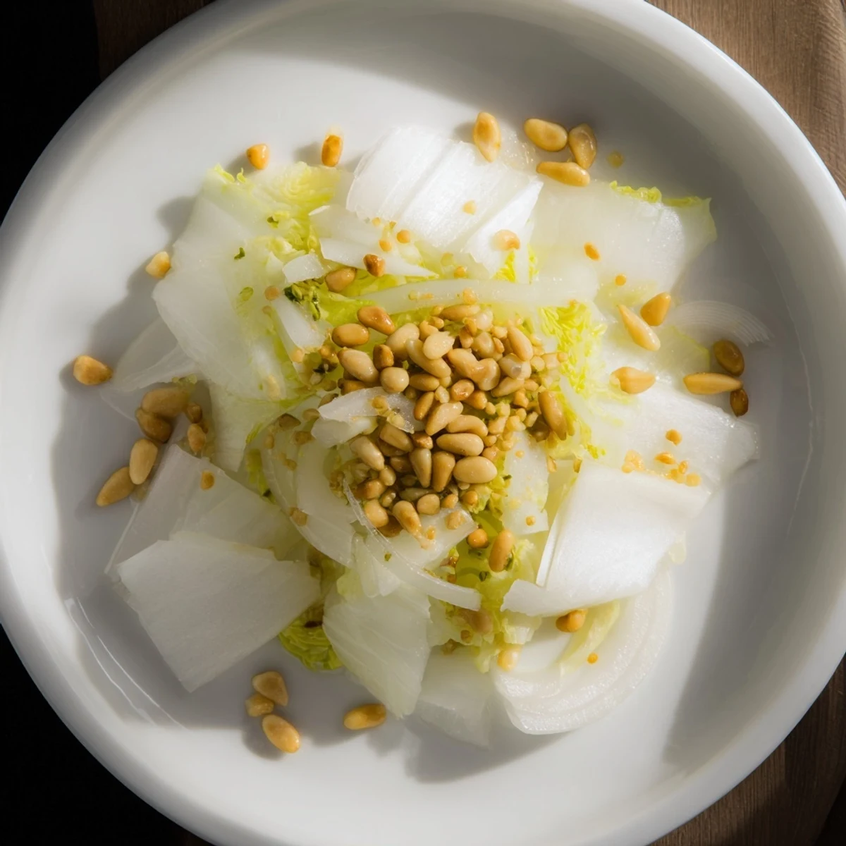 Sautéed Emerald Kale glistens, the vibrant green leaves accented with toasted pine nuts and lemon.