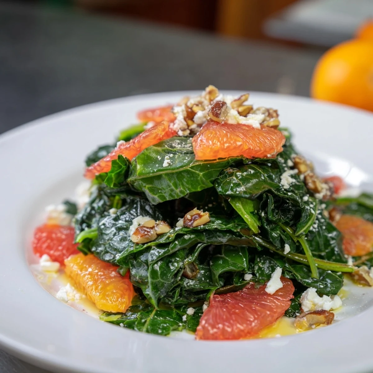 Cozy Citrus Greens salad featuring bright orange & grapefruit segments with toasted pecans, vibrant on a plate.