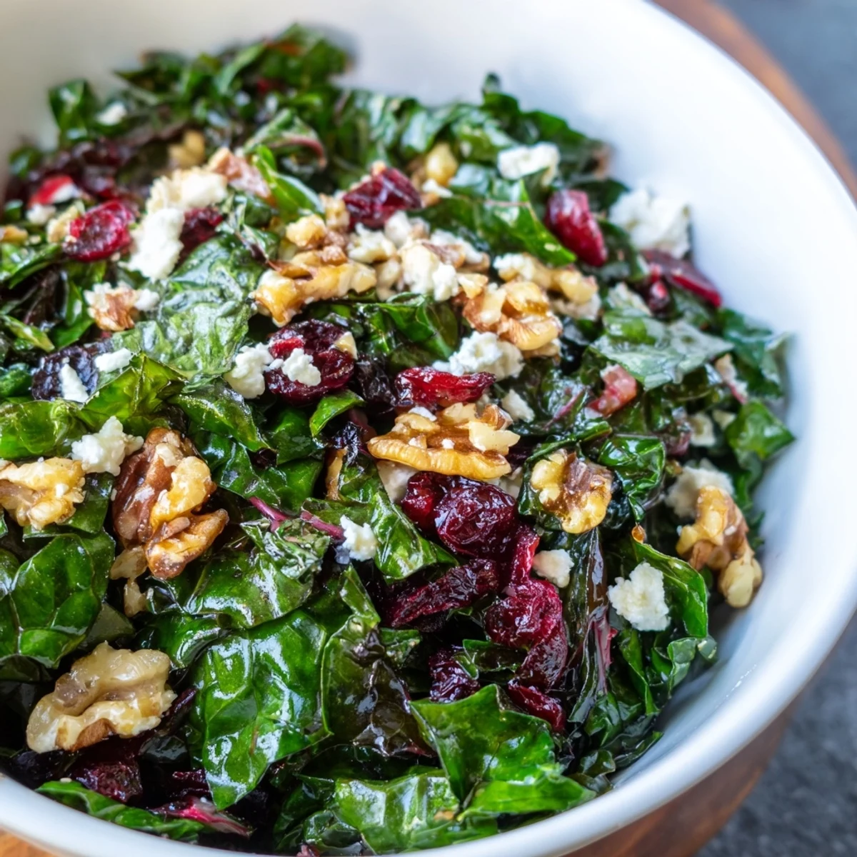 Snowy Winter Greens tossed in a citrus vinaigrette, featuring kale, chard, and spinach ready to serve.