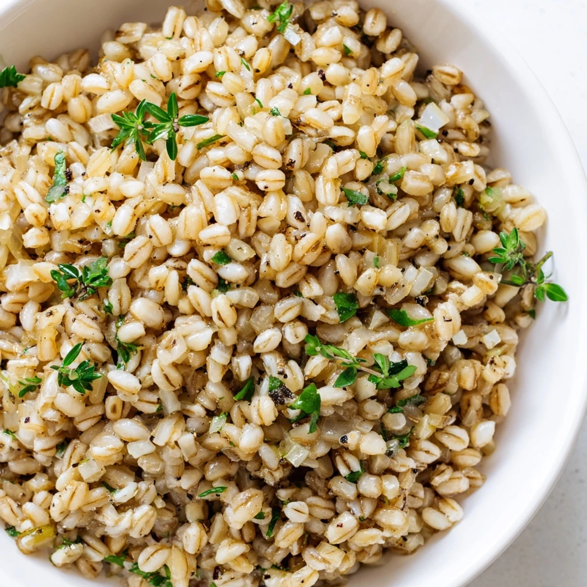 Spoon serving of nutty Toasty Barley with sautéed onions and garlic, steam rising from the tender grains.