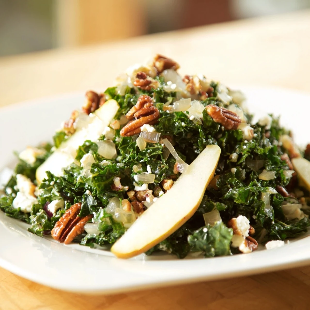 Savory-sweet Pear Kale Salad served in a rustic bowl, featuring vibrant greens, juicy pear slices, and crunchy toasted pecans. Drizzled with homemade dressing for a refreshing modern American side dish.