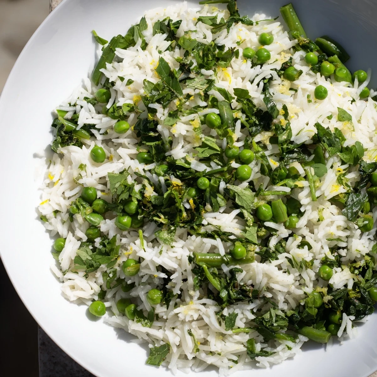 A vibrant serving of Emerald Warm Rice, featuring fluffy grains tossed with bright green peas, tender beans, and fresh herbs.