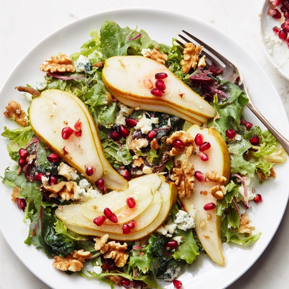 Crisp pear slices and toasted walnuts on a bed of vibrant winter greens, drizzled with tangy vinaigrette and topped with crumbled blue cheese.