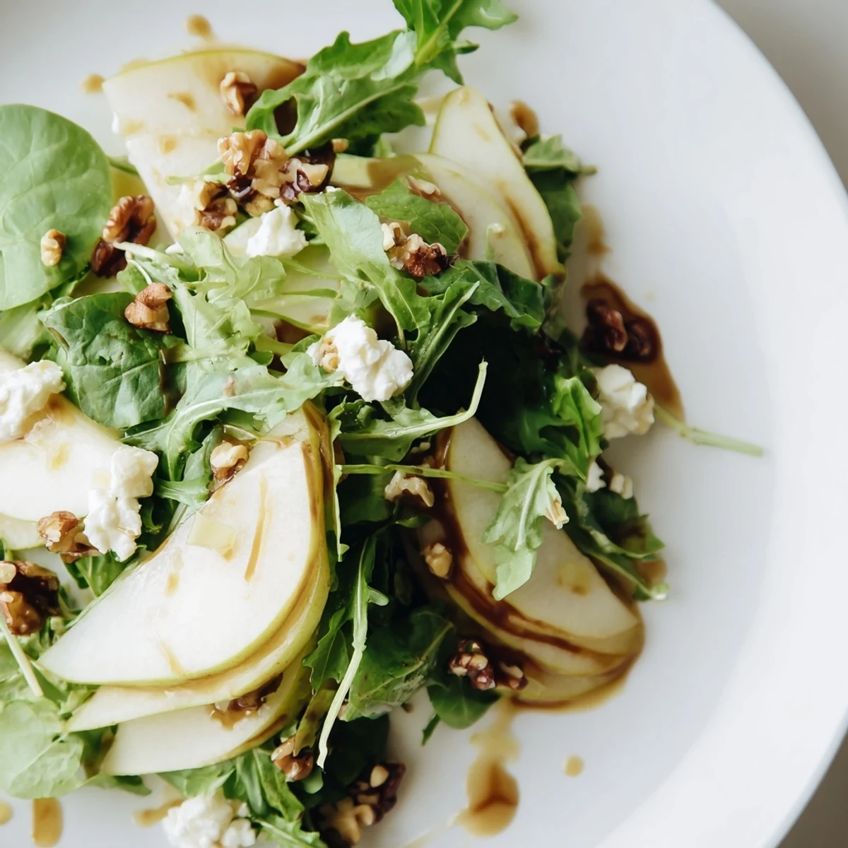 Fresh Evergreen Pear Greens salad with sliced pears, toasted pecans, crumbled goat cheese, and mixed baby greens tossed in a zesty vinaigrette.