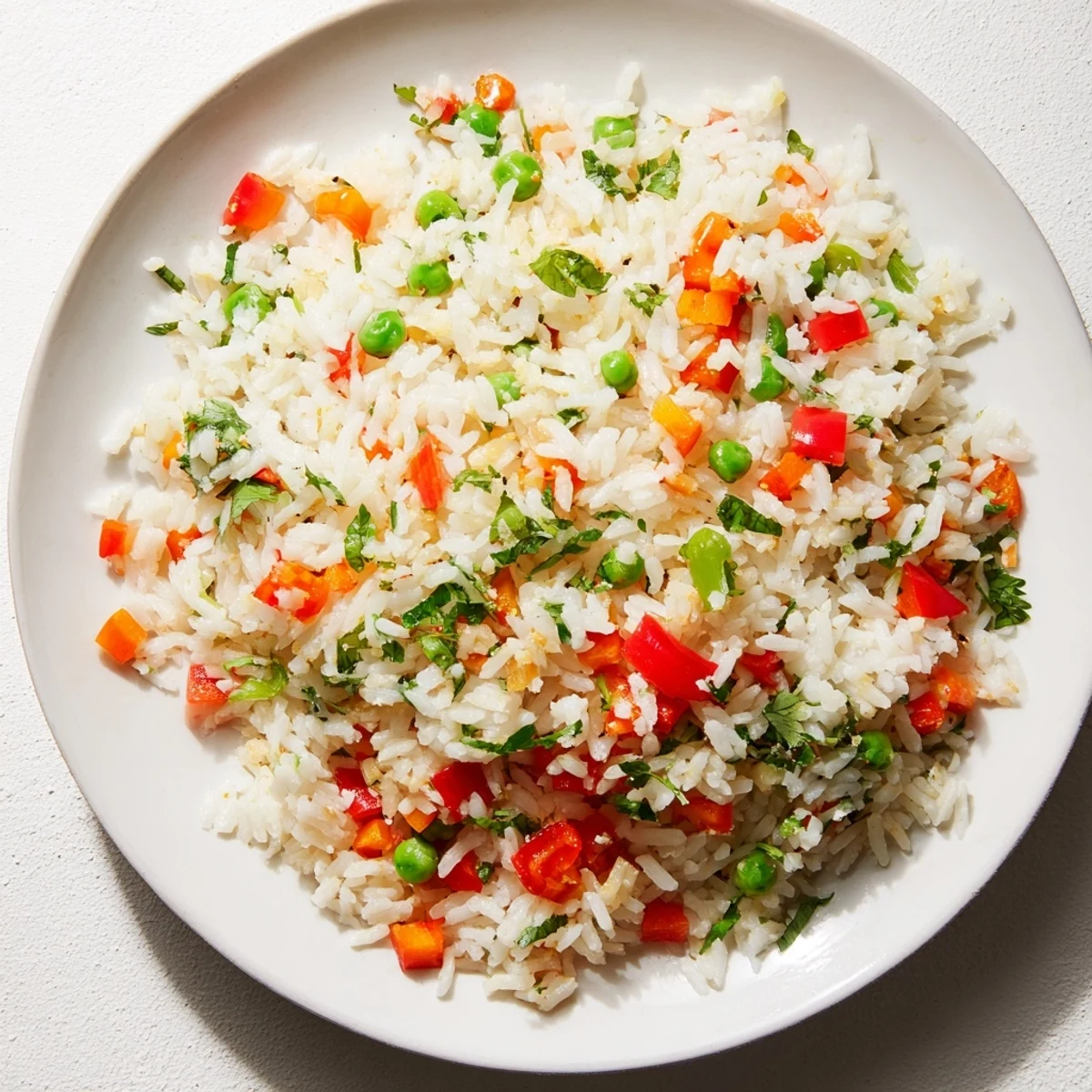 Bright Warm Rice with fluffy grains, colorful bell peppers, peas, and carrots, tossed with fresh parsley and cilantro for a vibrant, citrus-scented side dish.