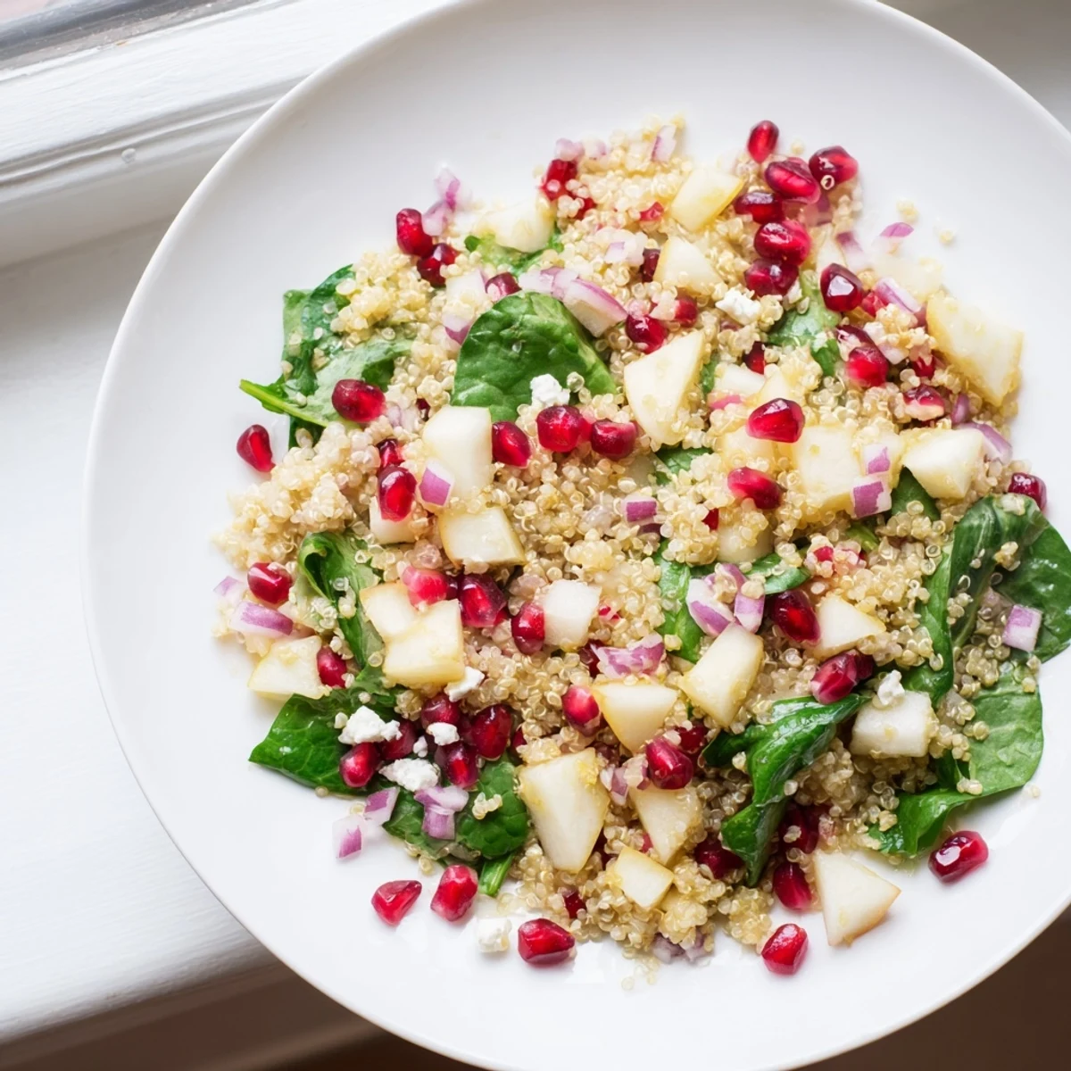 Fluffy quinoa, ripe diced pears, and pomegranate seeds tossed in a tangy lemon-honey vinaigrette for a refreshing salad.