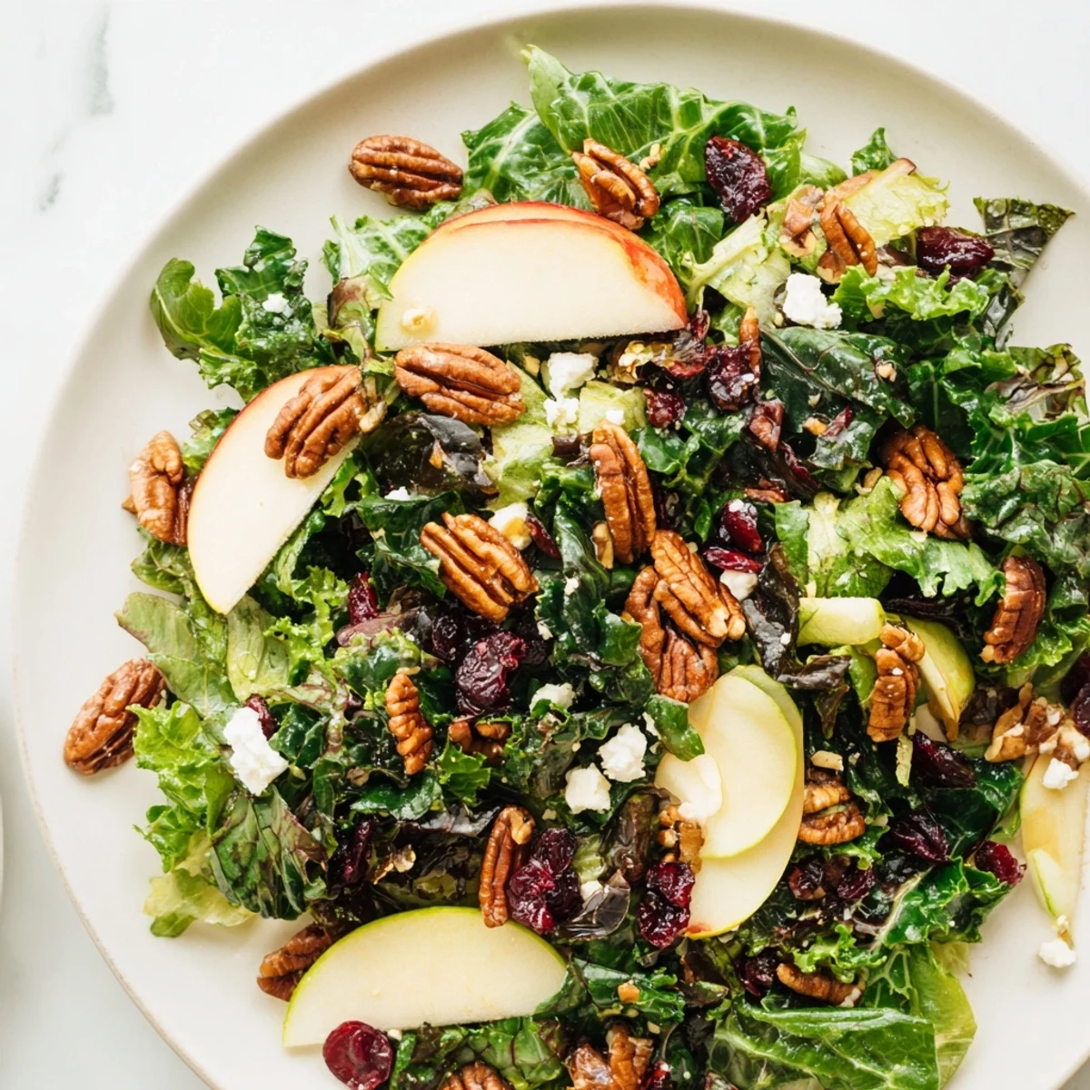 Easy gluten-free Harvest Winter Greens salad ready to serve with a drizzle of orange-Dijon vinaigrette and a sprinkle of crunchy nuts.
