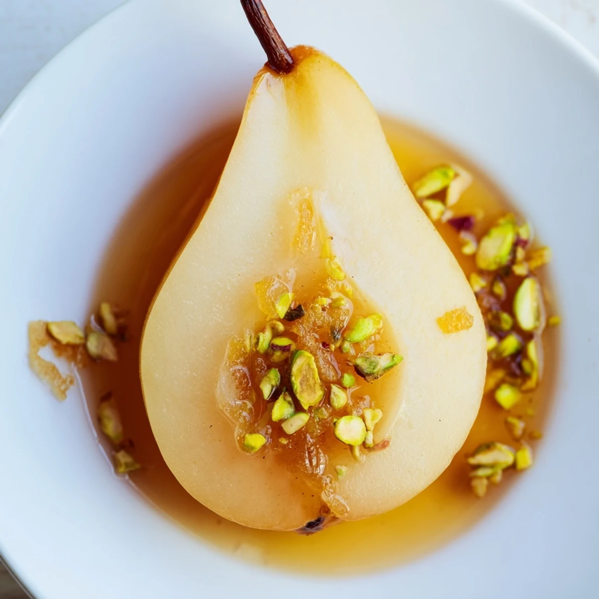 Ginger Ginger Pear dessert garnished with pistachios and syrup, served on a rustic plate for an elegant finish.