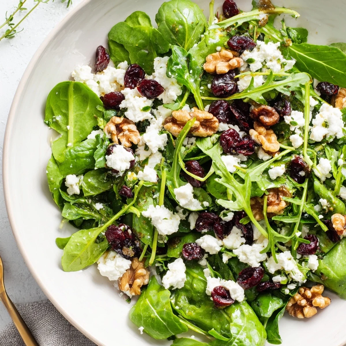 Vibrant Emerald Cranberry Herb salad tossed with feta, walnuts, and herbs served as a refreshing light lunch.  