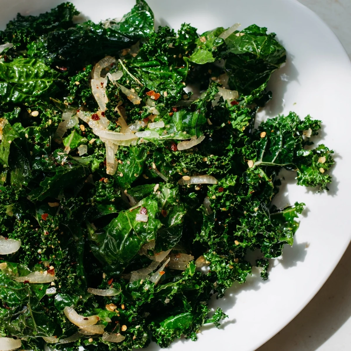 Sautéed ginger kale in a white bowl, garnished with optional sesame seeds, perfect beside grilled tofu or chicken.