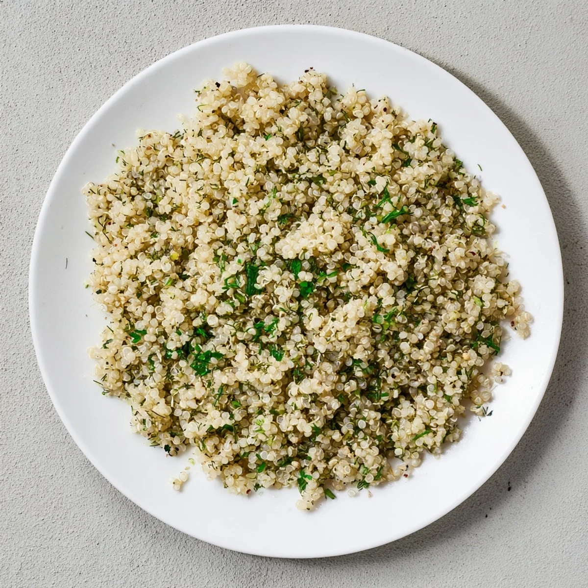 Steaming Herbed Quinoa in a white bowl, ready to accompany grilled chicken or veggies.