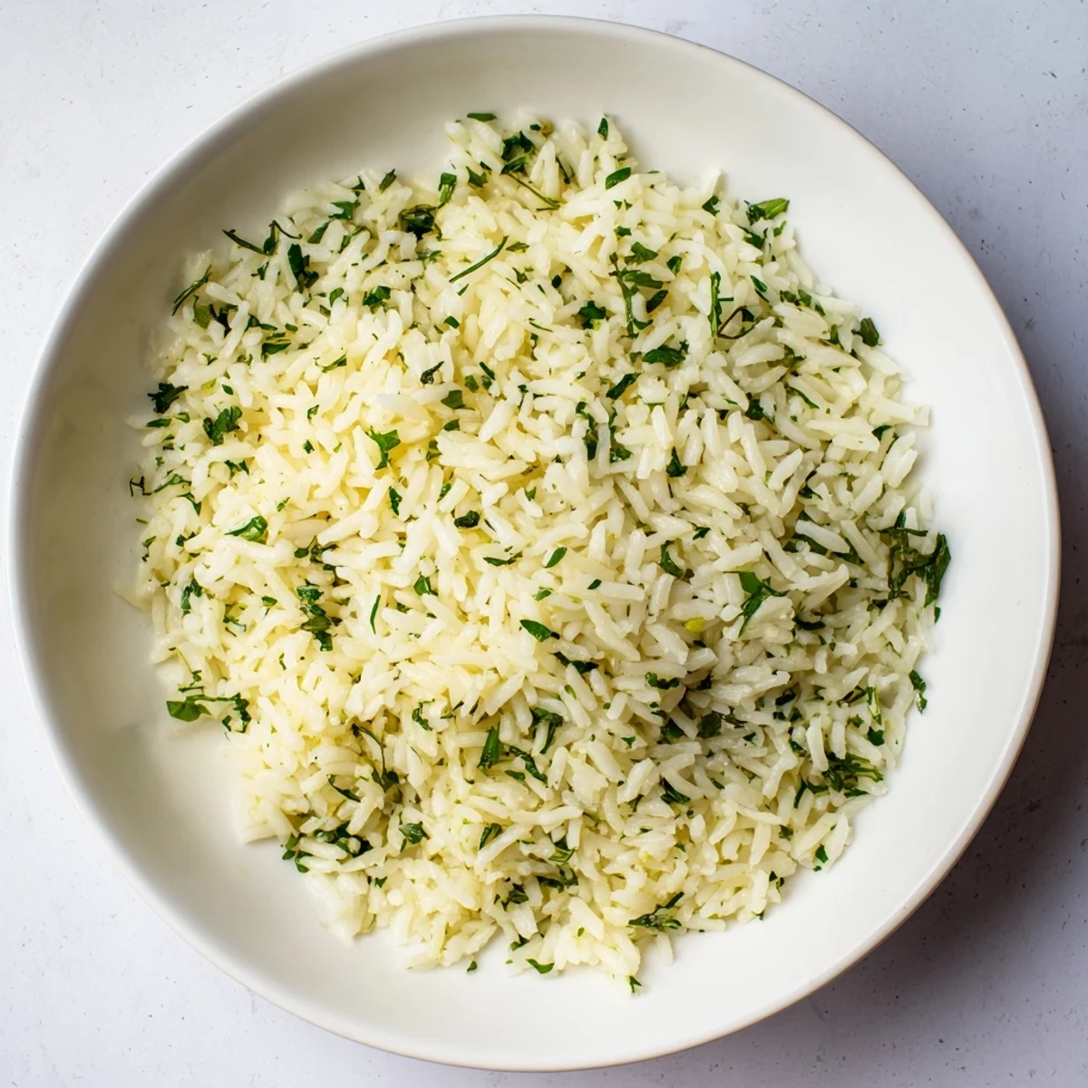 Steamed fluffy Herbed Warm Rice with fresh parsley and dill in a white bowl.