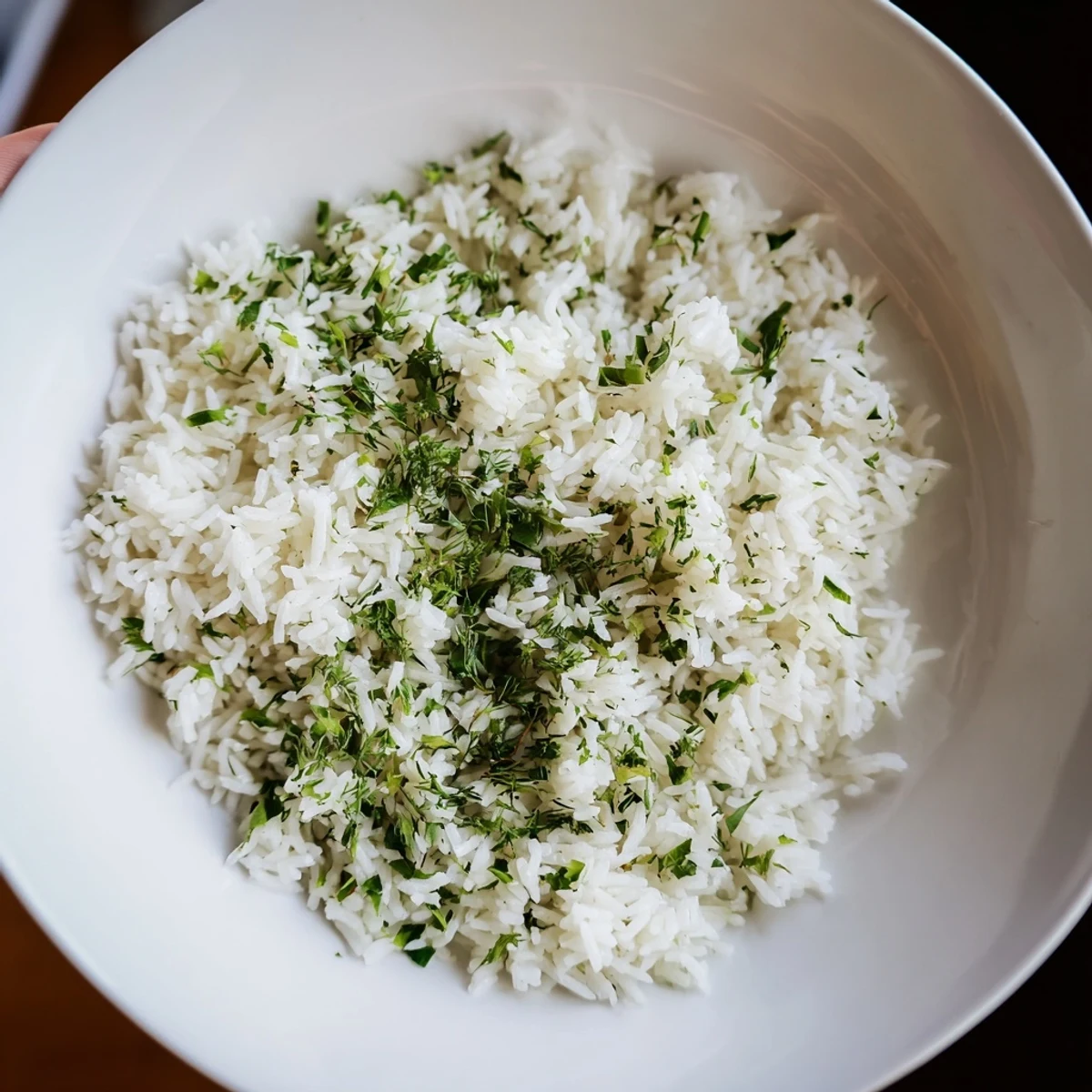 Steamed fluffy Herbed Warm Rice garnished with chopped herbs, served beside roasted chicken.