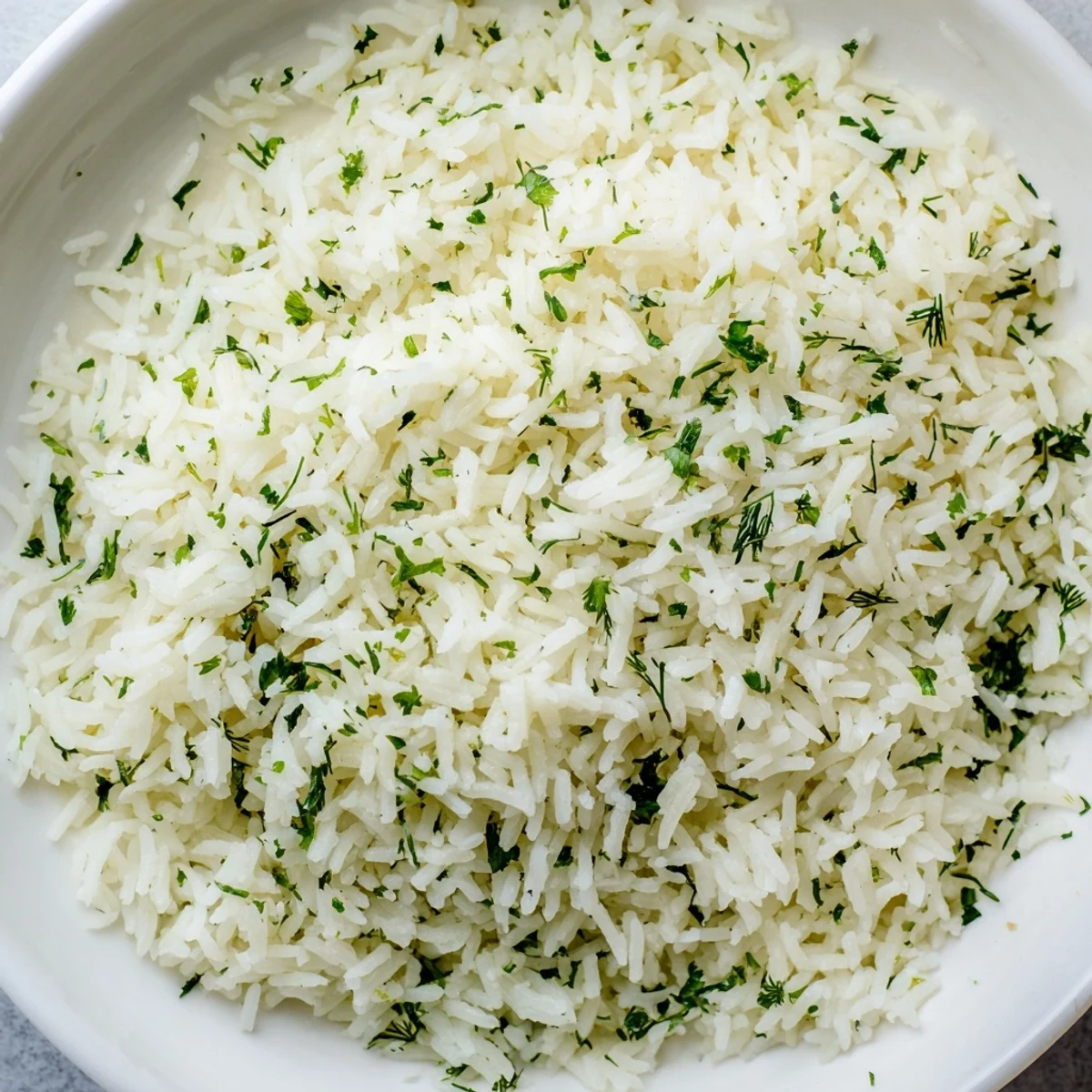 Warm bowl of Herbed Warm Rice featuring vibrant green herbs and tender long grains.