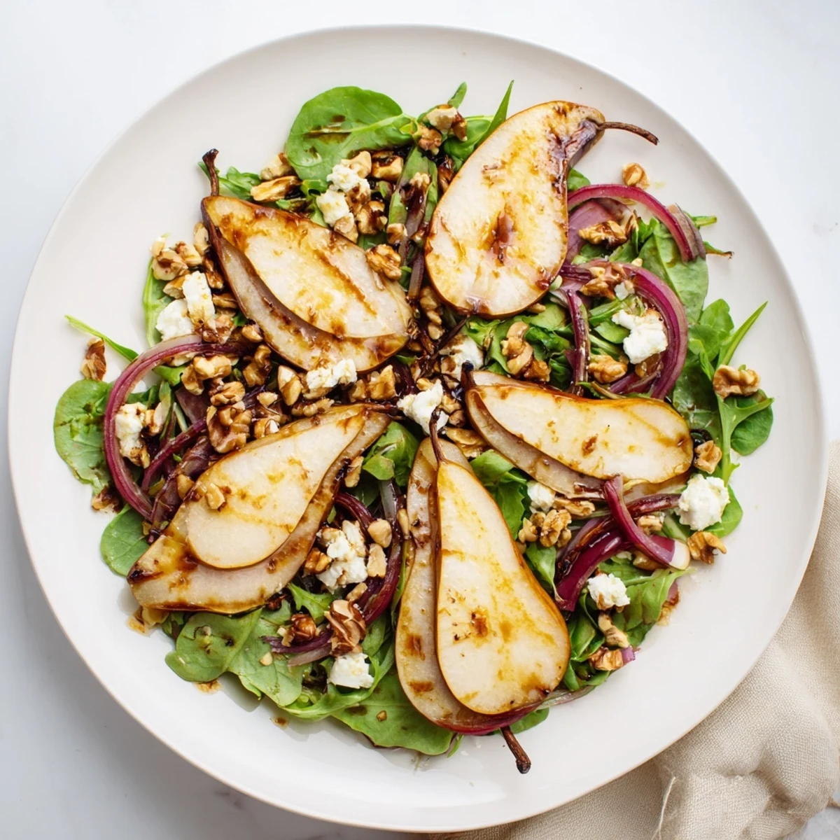 A vibrant Hearth Pear Greens salad with roasted fruit, tender greens, and crumbled cheese.
