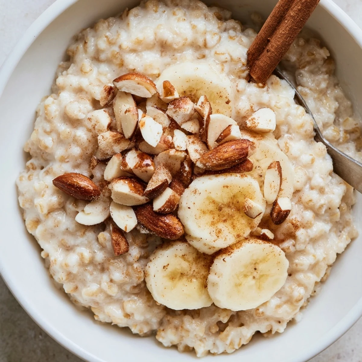 A steaming bowl of ginger barley porridge topped with fresh berries and toasted almonds for a wholesome breakfast.