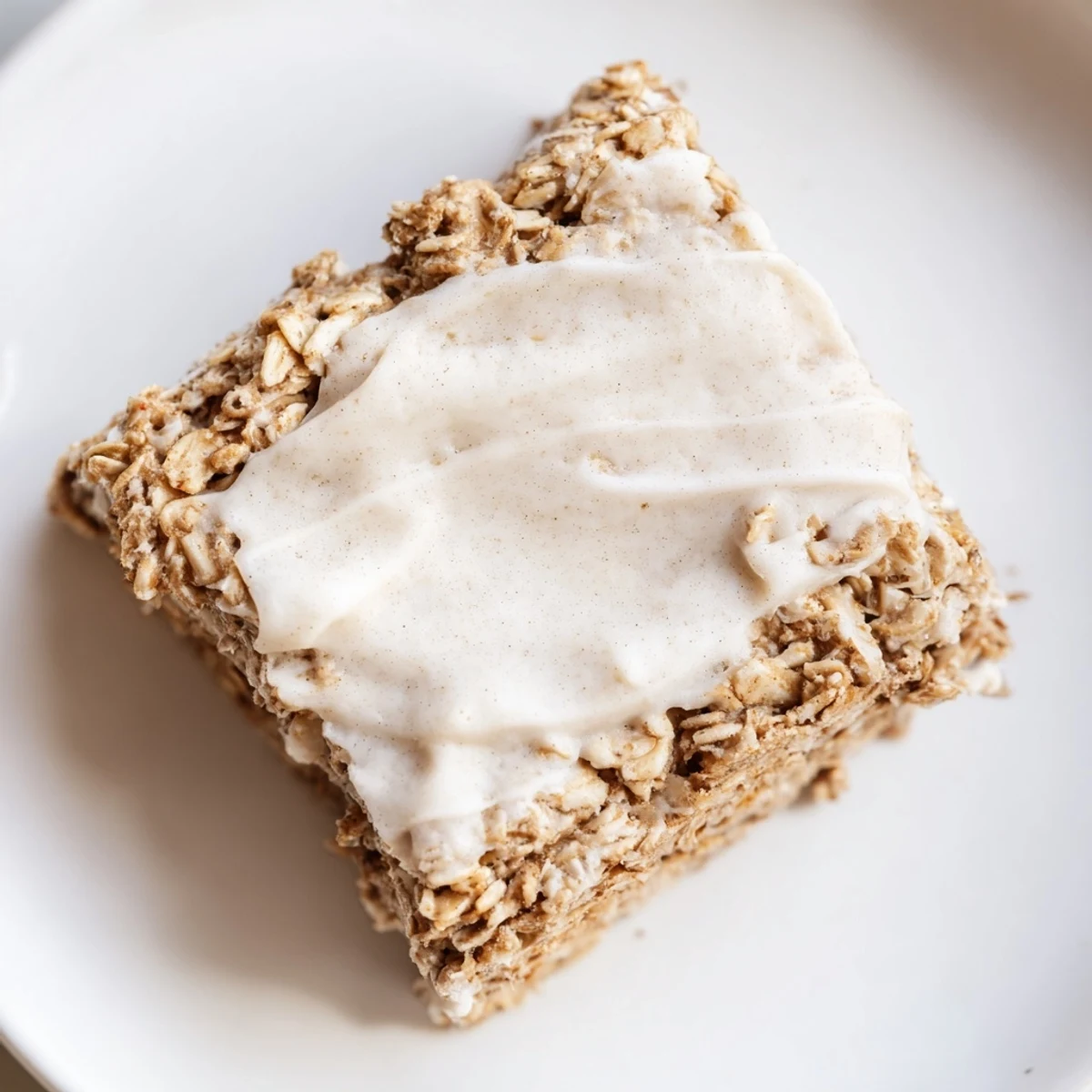 Soft Frosted Chai Oat breakfast squares topped with cream cheese frosting, perfect for cozy mornings with coffee.