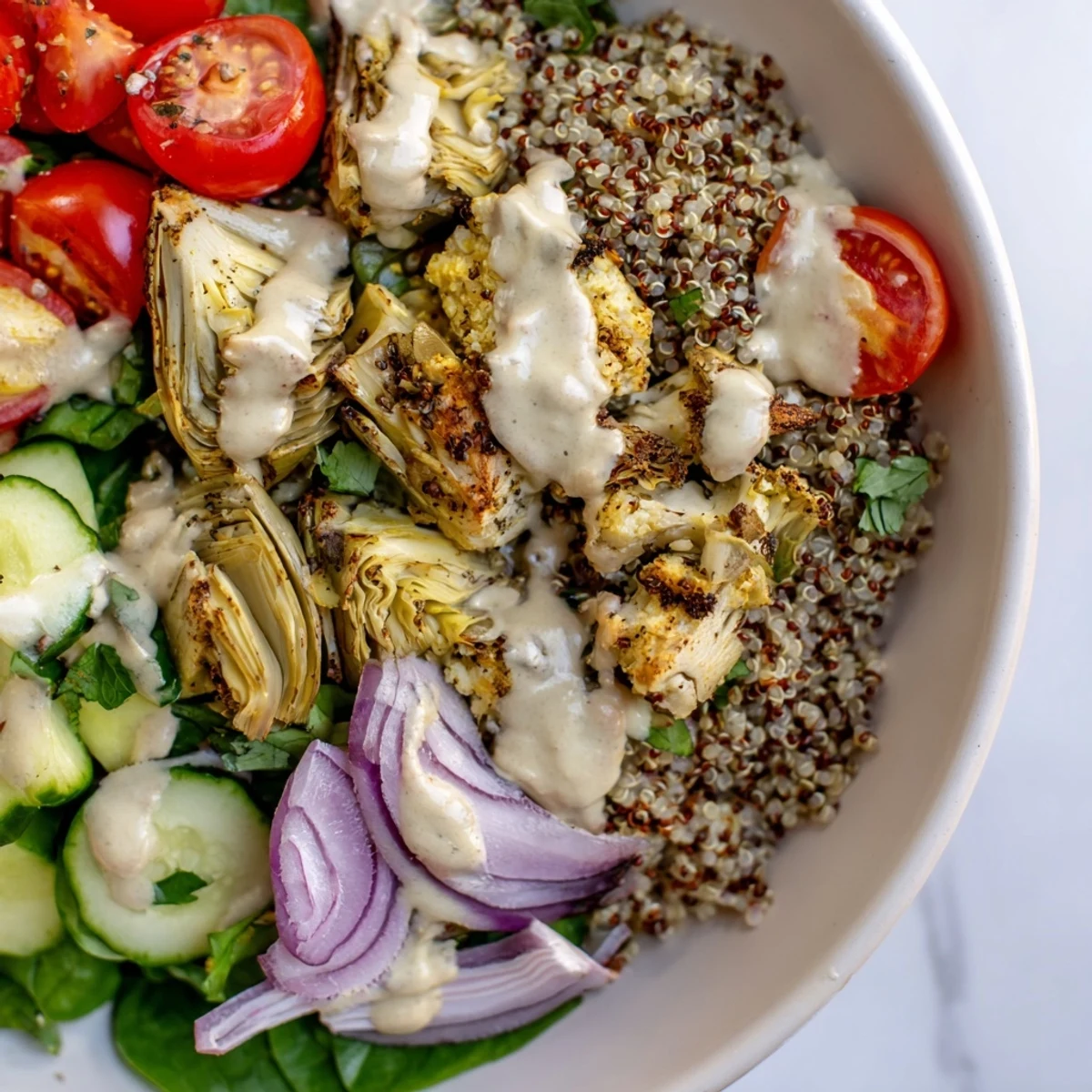 Served with a lemon wedge, this nutritious Lemon Tahini Quinoa Grain Bowl highlights a creamy tahini drizzle over quinoa.