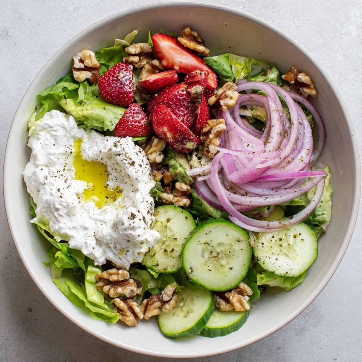 A Mediterranean-inspired Whipped Feta and Roasted Strawberry Salad Bowl shows creamy whipped feta, sweet balsamic-roasted berries, fresh mint, and a drizzle of olive oil.