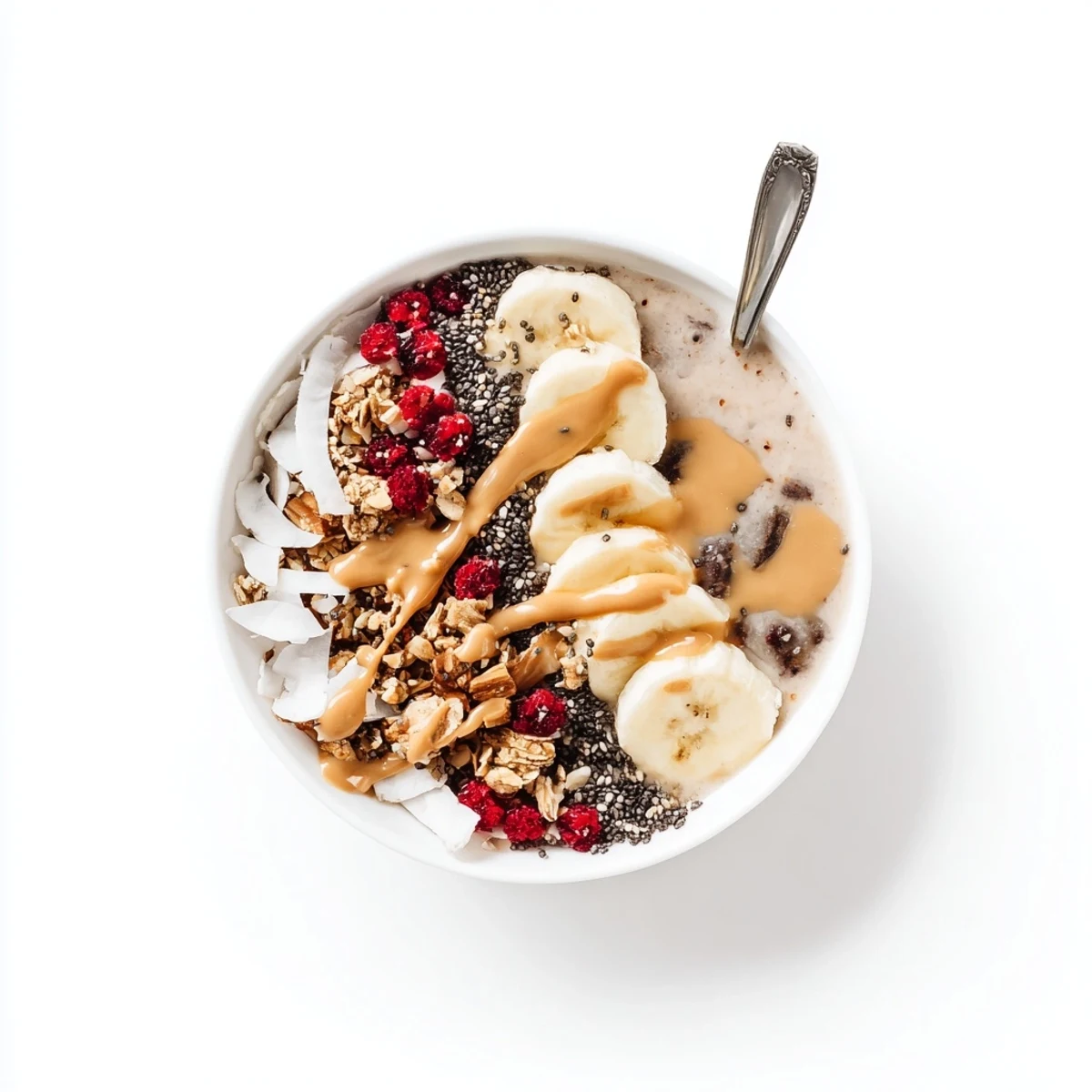 A vibrant black sesame banana smoothie bowl with coconut flakes and cacao nibs ready to eat.