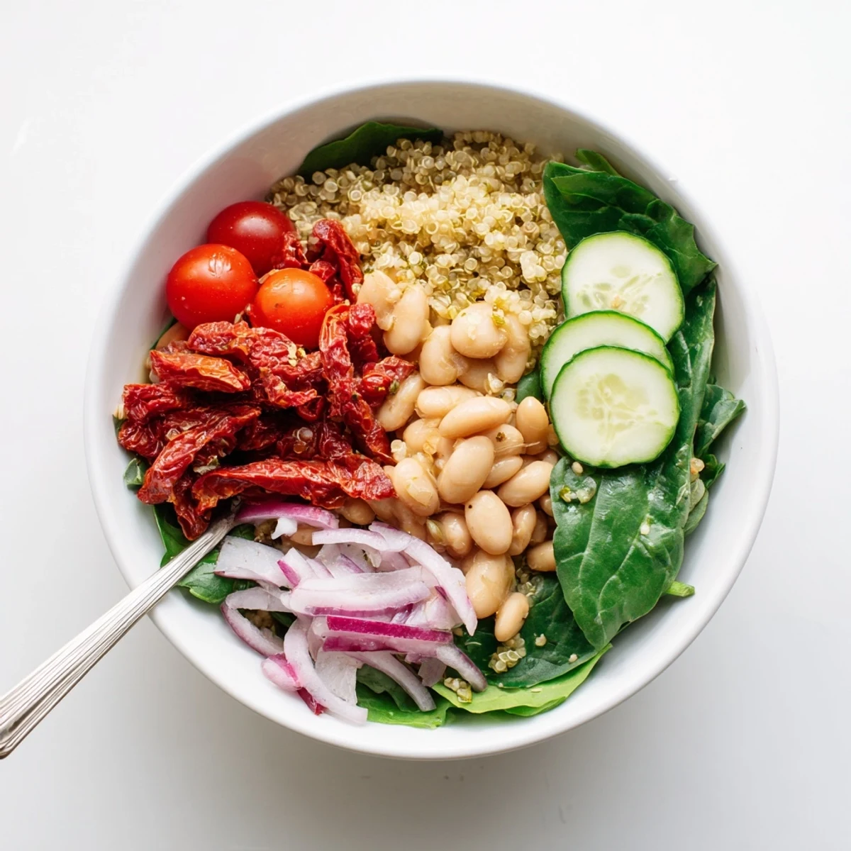 This Sun-Dried Tomato and White Bean Vegan Bowl is topped with fresh basil and toasted pine nuts for extra crunch.