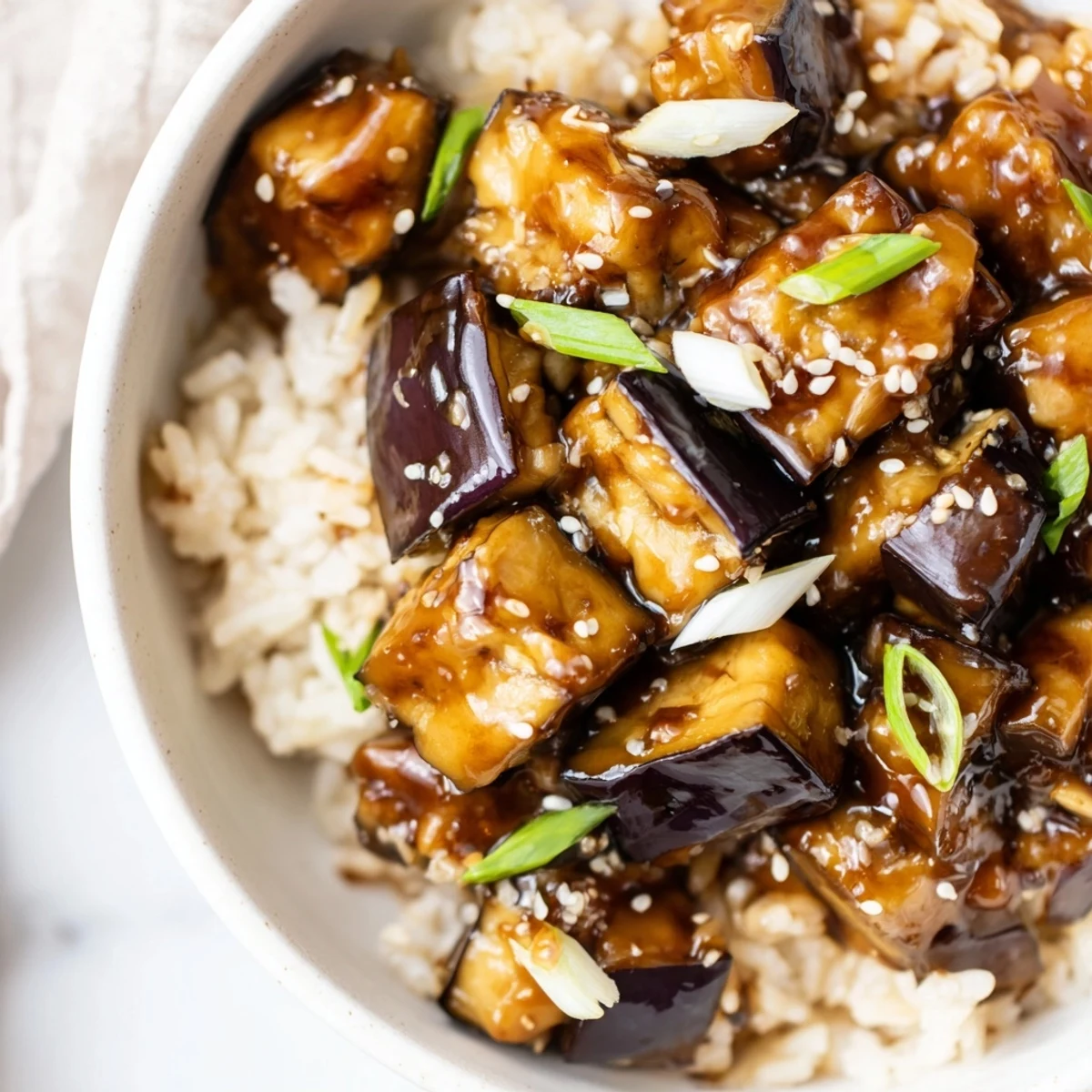 Steaming Miso Glazed Eggplant Rice Dish with Scallions is ready to serve, paired with a side of quick pickled ginger for a vibrant meal.