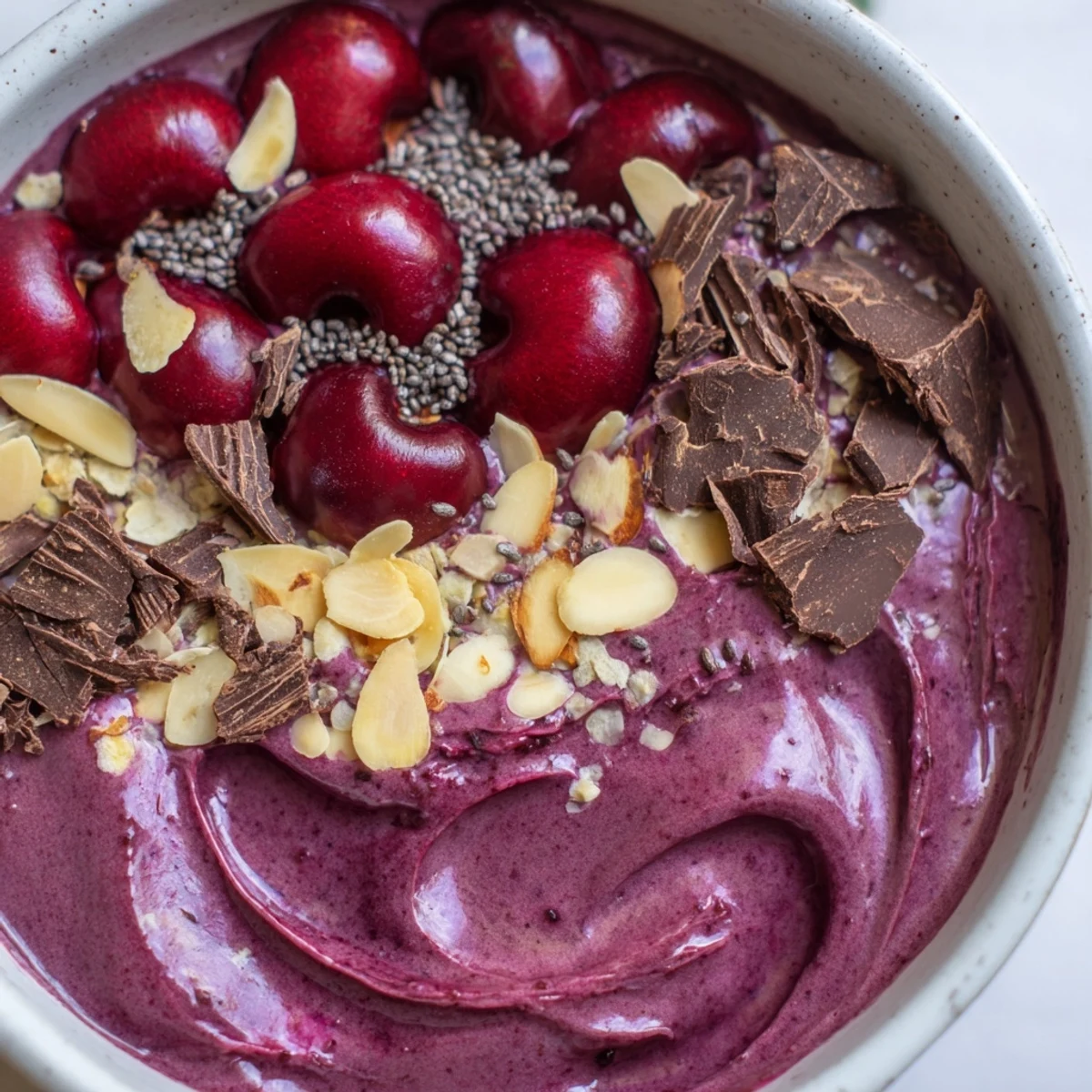 Thick, creamy Cherry Almond Smoothie Bowl with dark chocolate shavings and fresh cherries on top.  