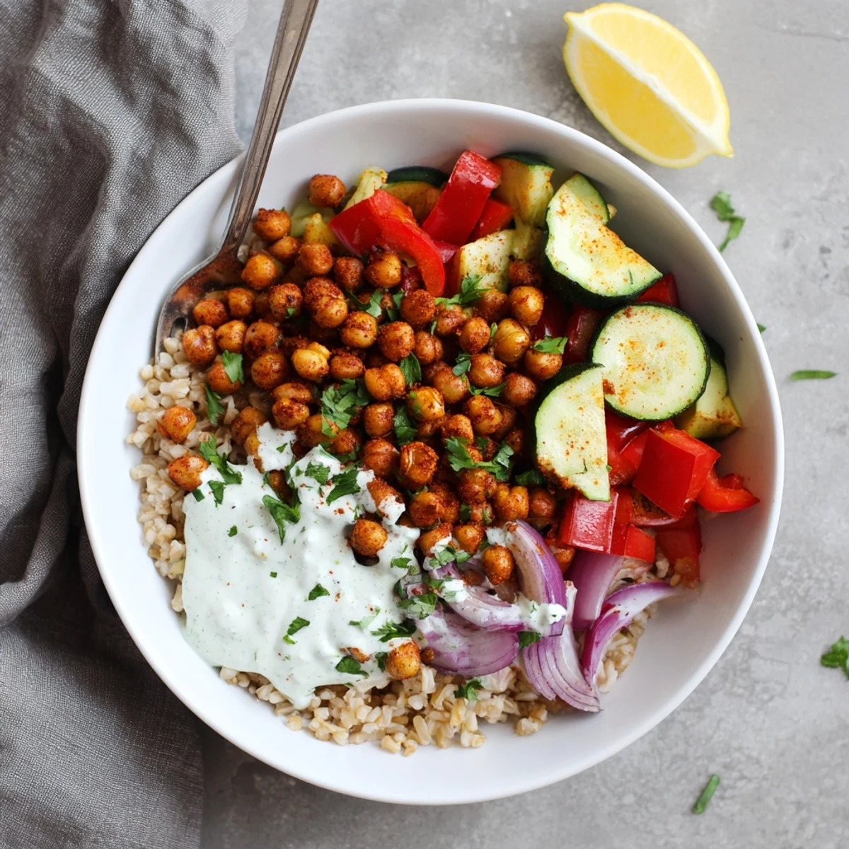 Steaming Smoky Paprika Chickpea Veggie Bowl with Lemon Yogurt drizzled generously, surrounded by colorful roasted vegetables on a rustic table.