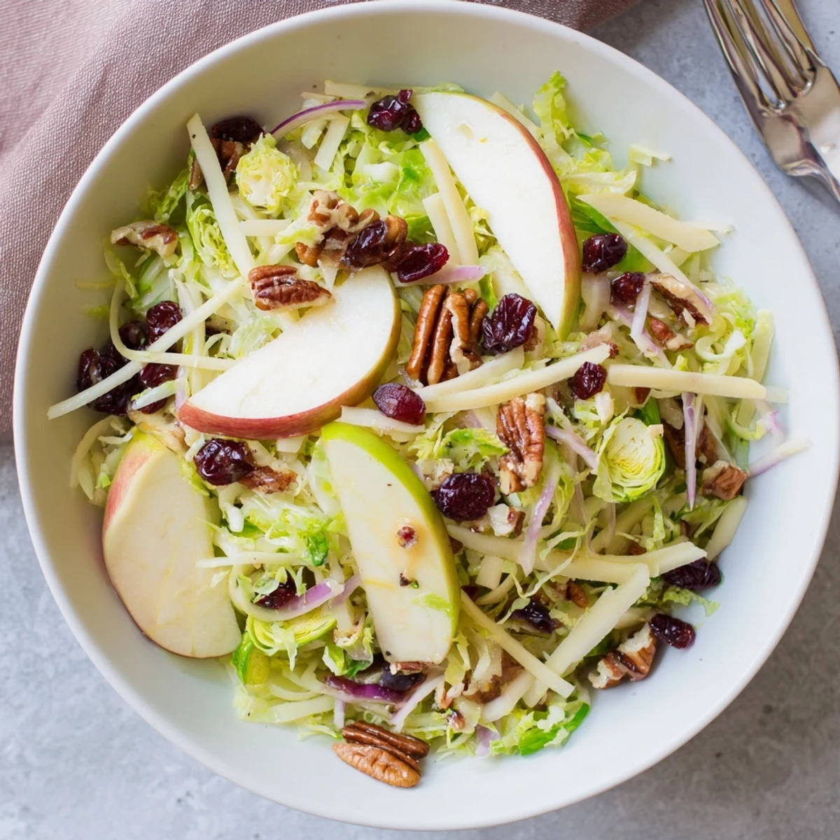 Bright green shaved Brussels sprouts and crisp apple slices topped with golden candied pecans in a lemon-Dijon vinaigrette.
