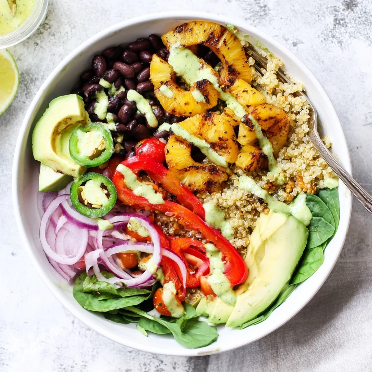 Served with lime wedges, the Charred Pineapple Jalapeño Grain Bowl has smoky fruit, spicy peppers, and fresh greens.