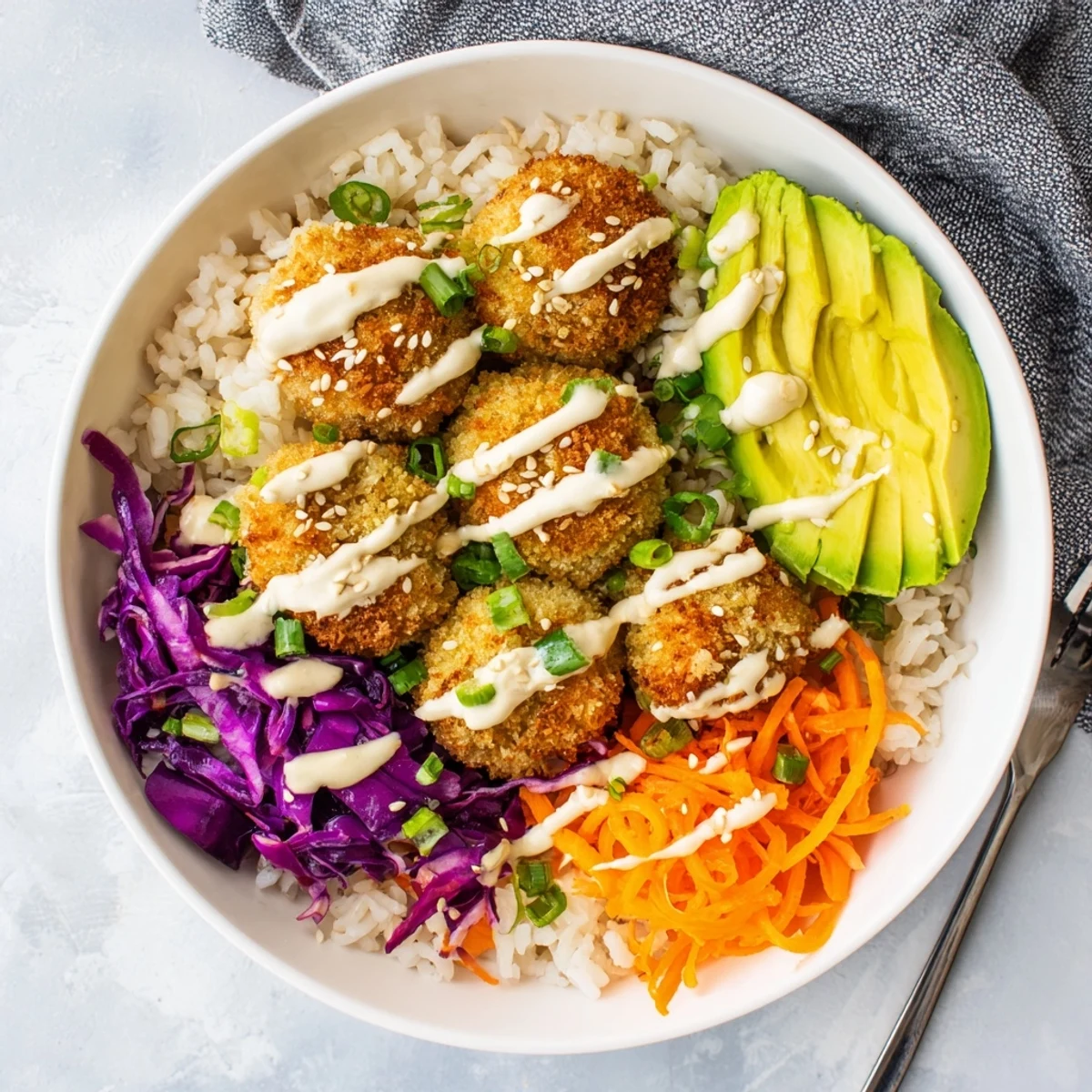 Golden crispy bang bang broccoli bowl drizzled with spicy sesame sauce over fluffy rice