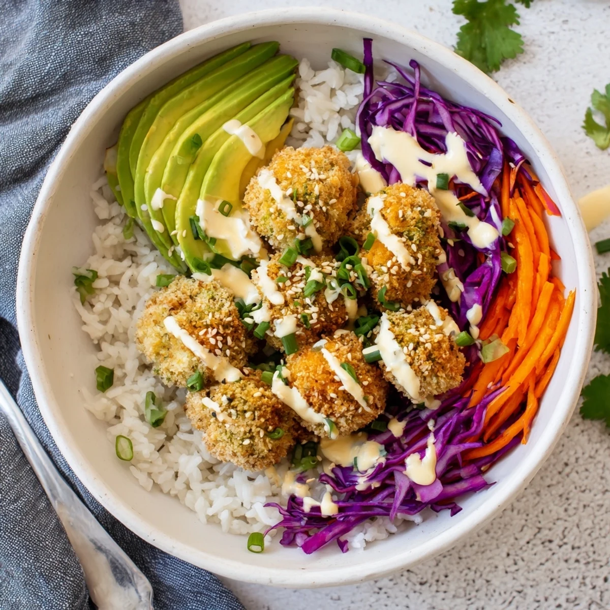 Colorful plant-based bowl with crispy bang bang broccoli served over rice and fresh vegetables