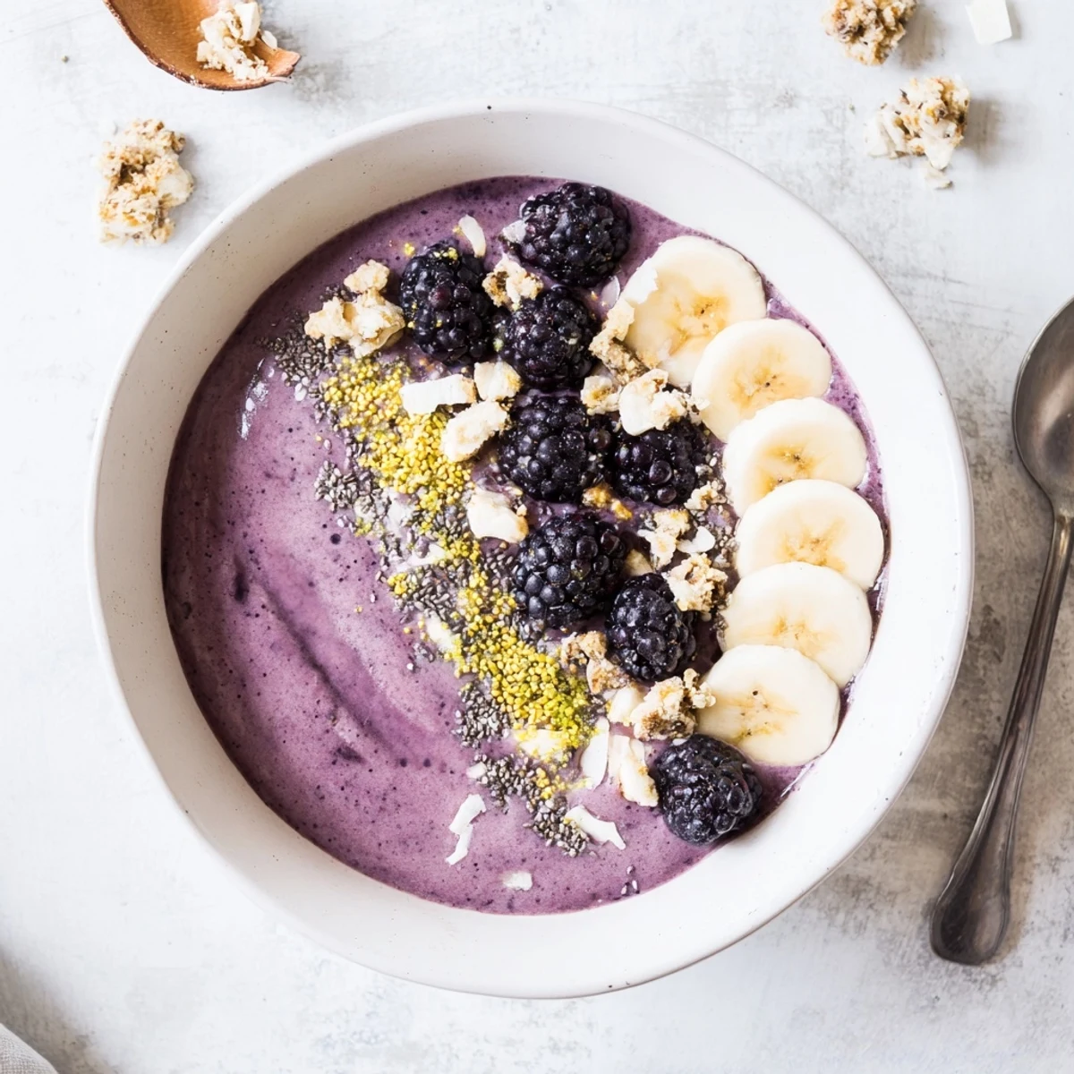 Thick purple Blackberry Vanilla Cashew Smoothie Bowl topped with fresh berries, crunchy granola, and golden bee pollen