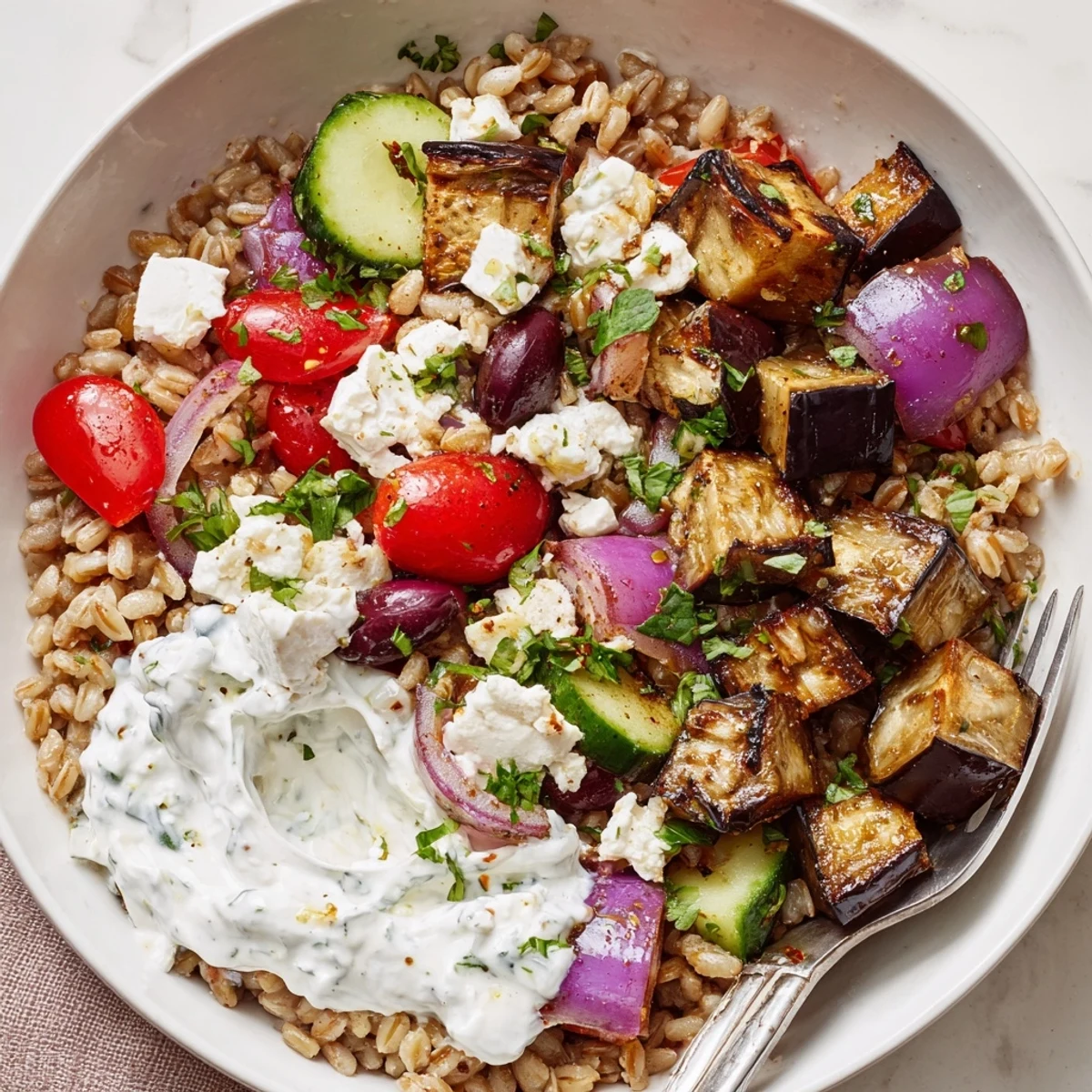 Wholesome Mediterranean bowl with tender roasted eggplant, fluffy grains, and refreshing tzatziki topping