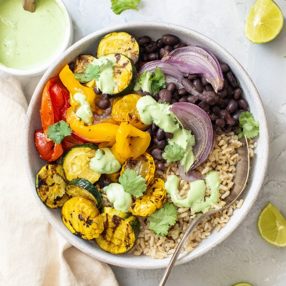 Fresh vegetarian zucchini bowl with roasted vegetables and smooth avocado lime crema sauce