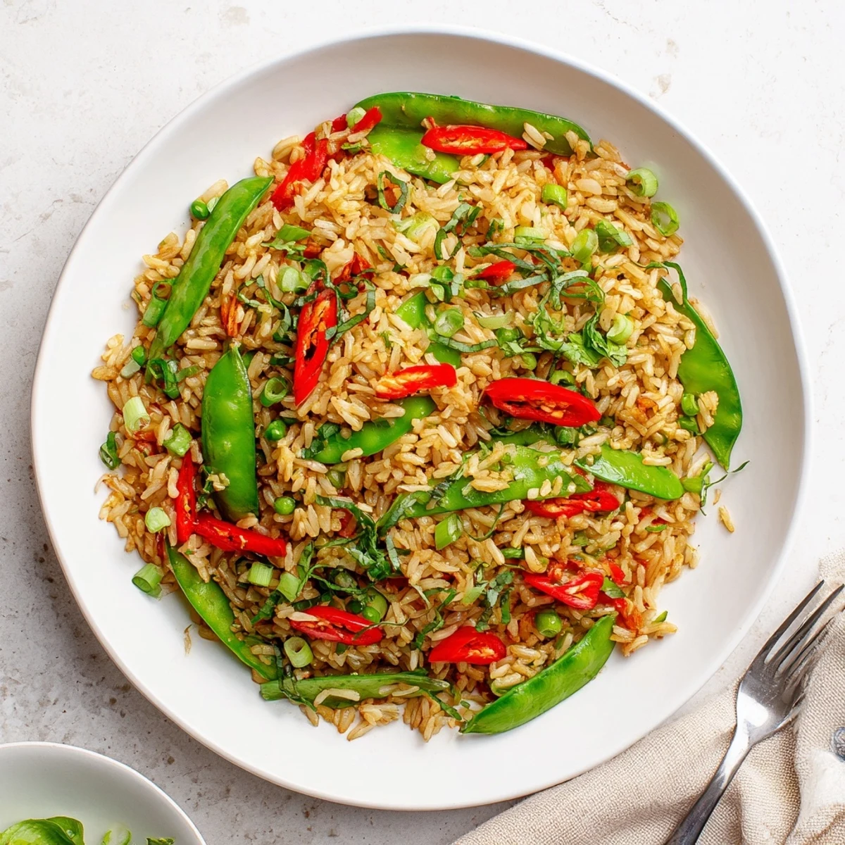 Vibrant Thai basil garlic fried rice featuring red peppers and fresh green herbs