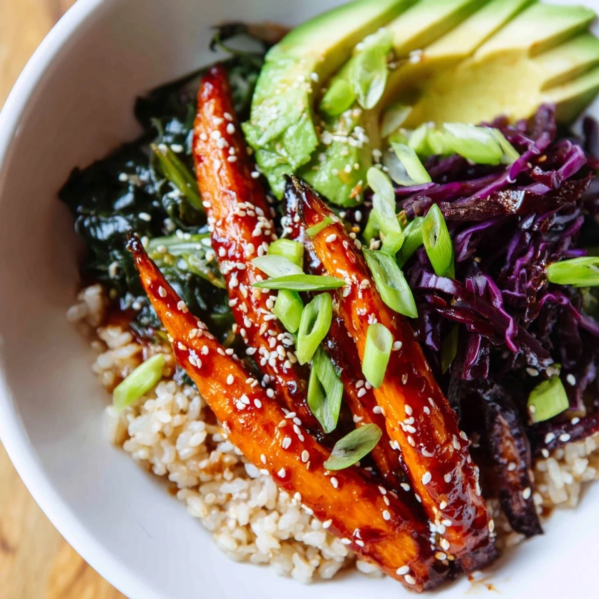 Close-up of Korean-inspired spicy gochujang roasted carrot veggie bowl featuring caramelized carrots, wilted sesame greens, and vibrant toppings
