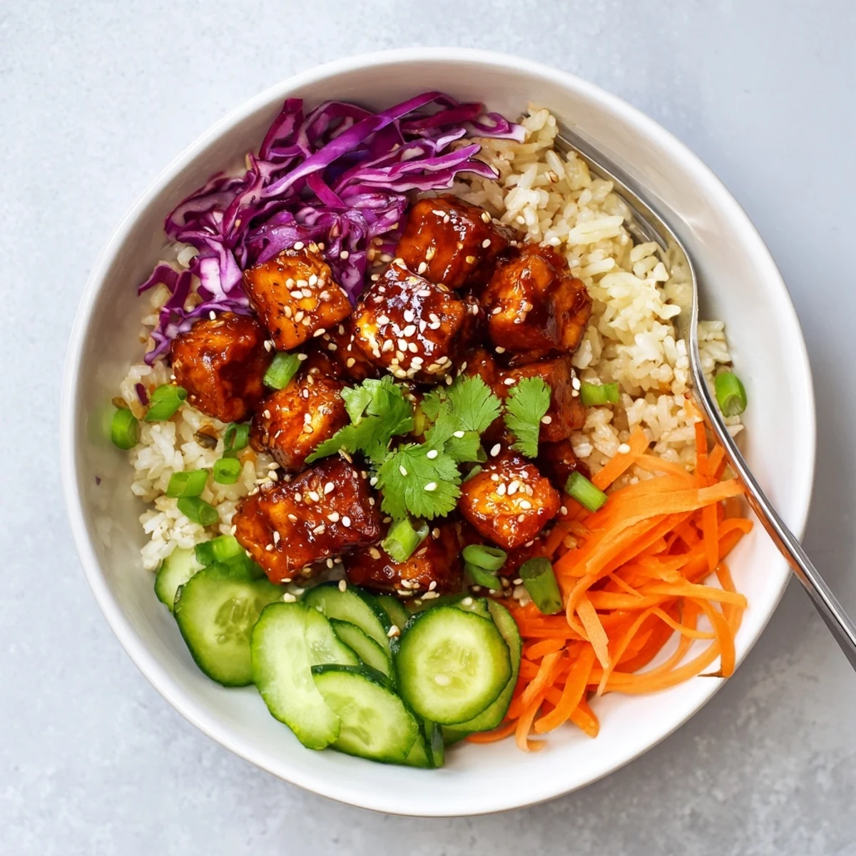 Golden crispy tofu cubes coated in glossy sweet orange glaze atop fluffy white rice