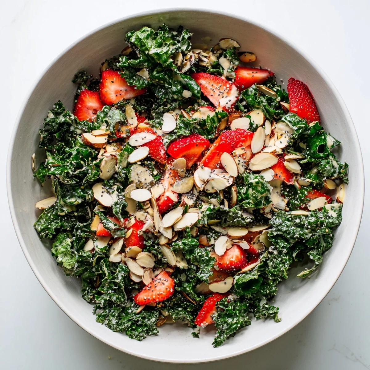 Crispy kale strawberry almond salad bowl with poppyseed drizzle featuring roasted kale chips