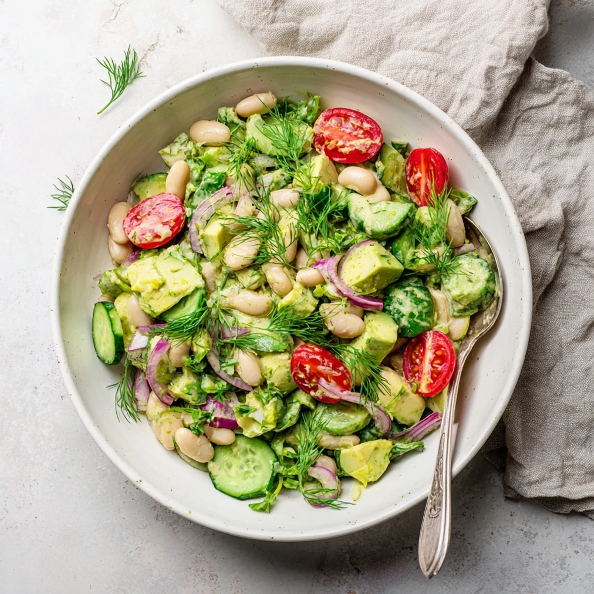 Vibrant white bean salad bowl featuring ripe avocado, tender beans, and bright lemon dill dressing