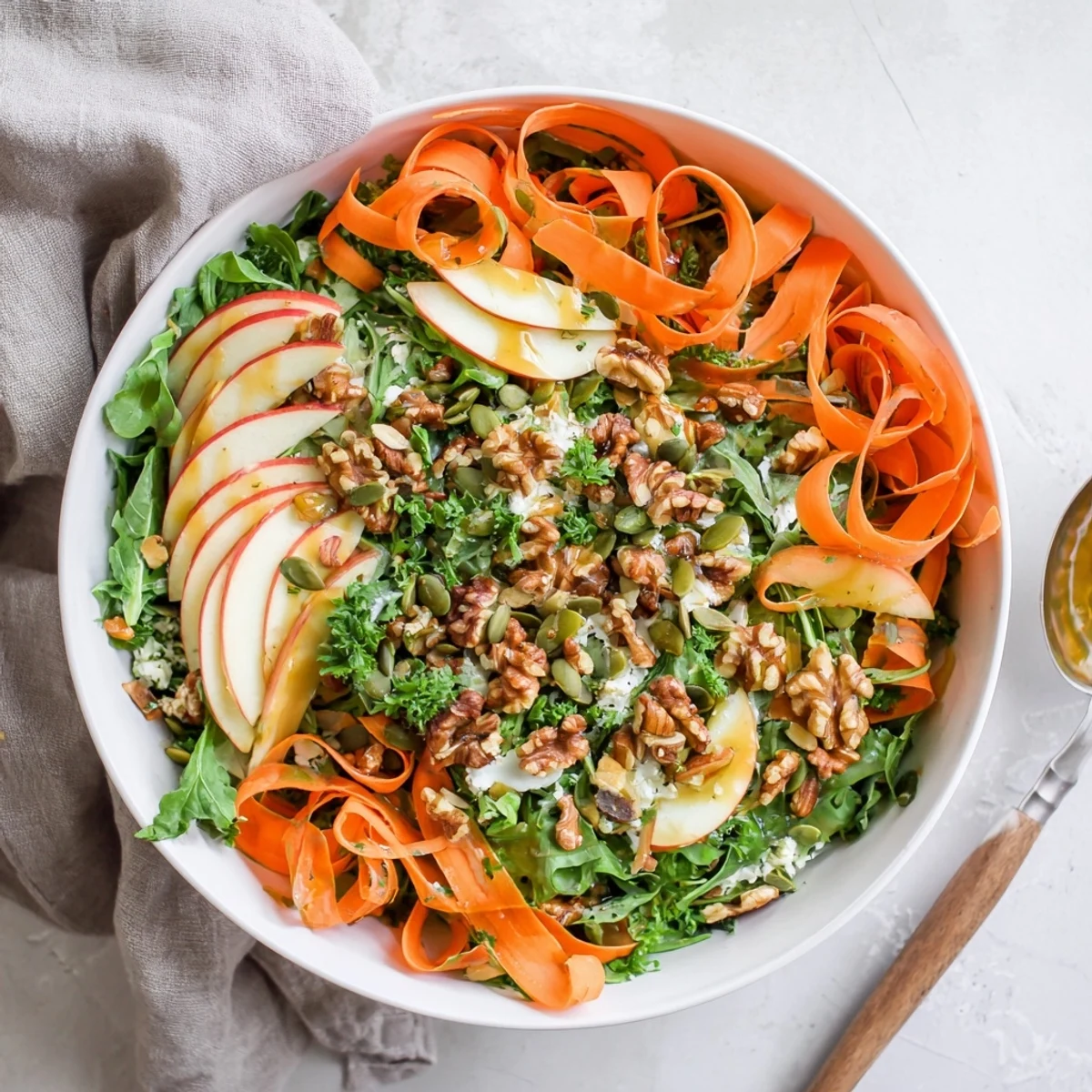 Fresh shaved carrot apple walnut salad bowl with glossy maple dressing