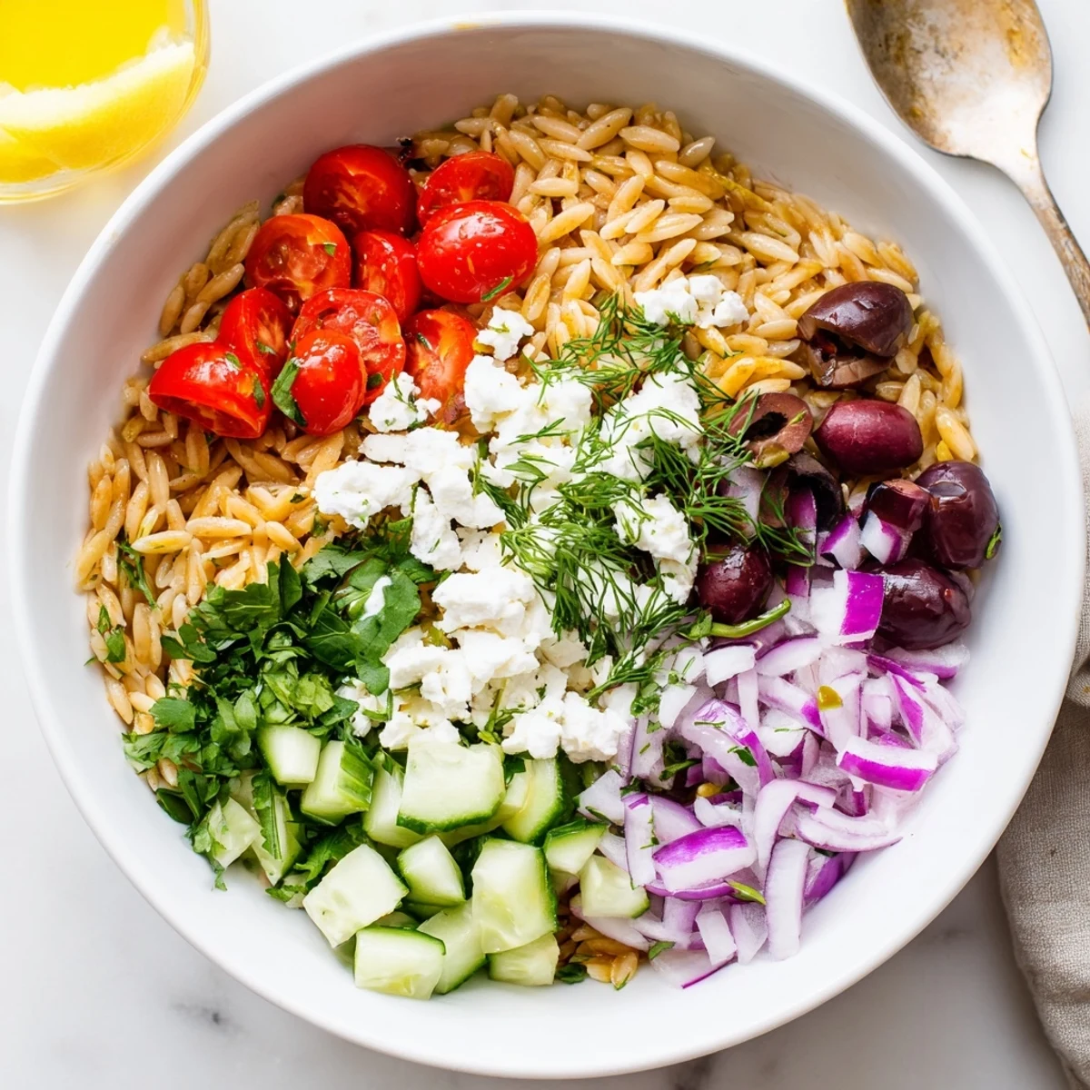 Vibrant bowl of roasted tomato orzo with crisp vegetables and tangy lemon olive oil dressing