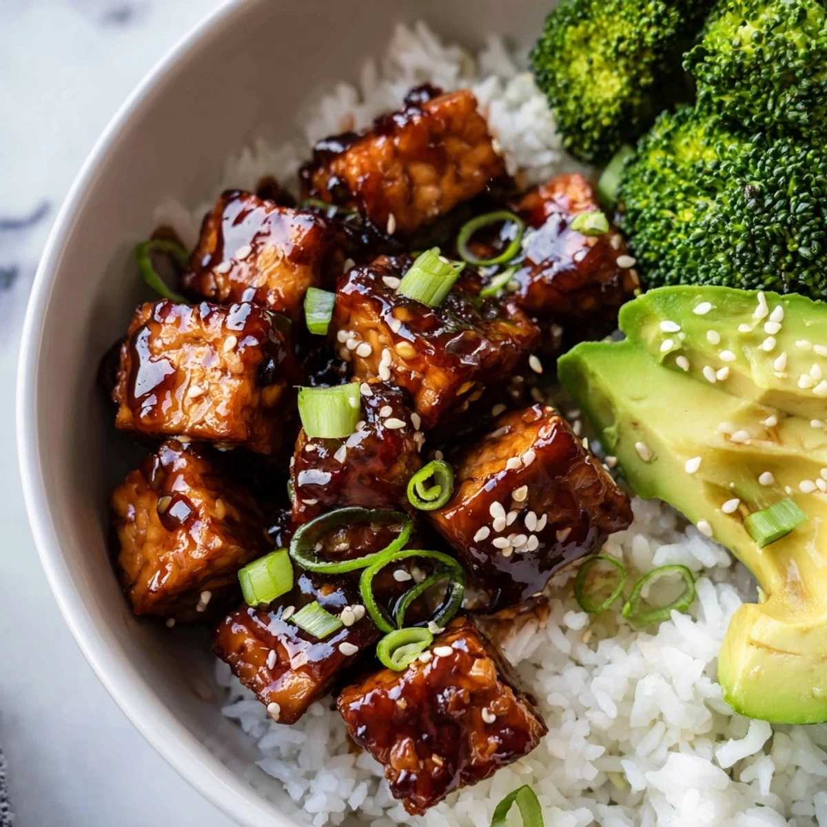 Golden teriyaki tempeh glazed in sweet sticky sauce over fluffy white rice