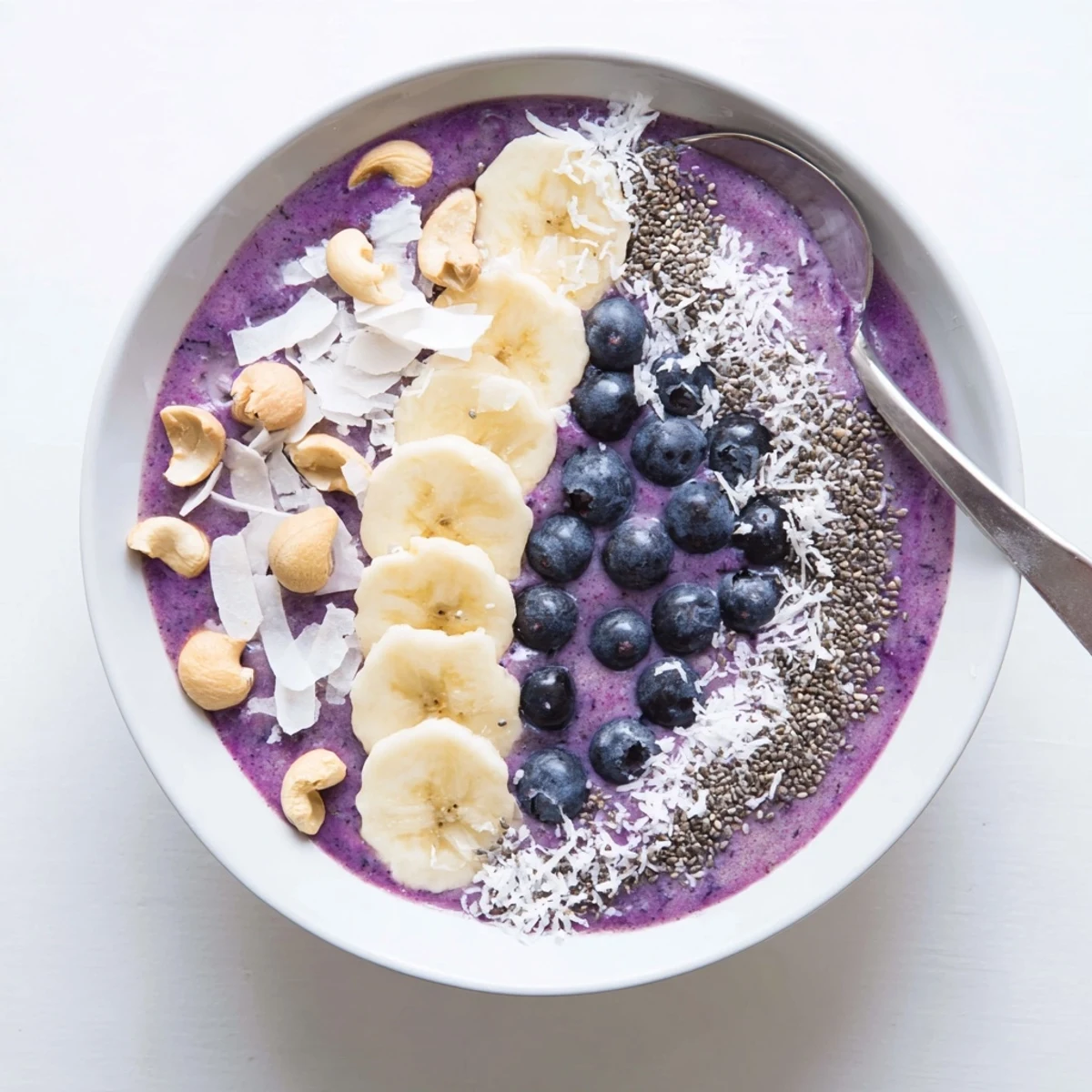 Vegan blueberry vanilla cashew smoothie bowl sprinkled with nutritious chia seeds and crunchy cashew toppings