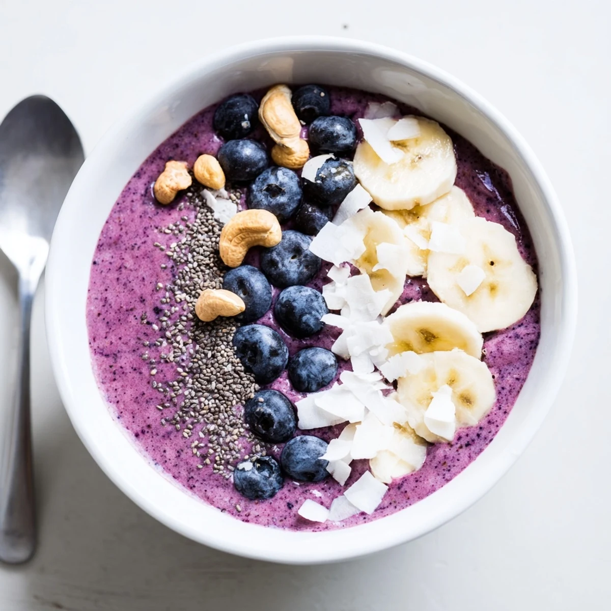 Creamy purple smoothie bowl with swirls of blueberry vanilla blend garnished with white chia seeds