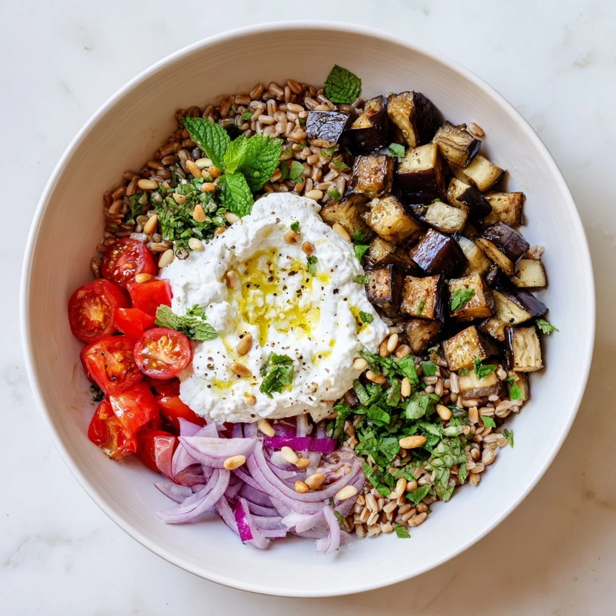 Colorful vegetable grain bowl topped with creamy lemon yogurt and fresh Mediterranean herbs
